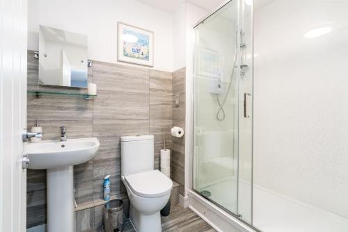 ein Bad mit einem WC, einem Waschbecken und einer Dusche in der Unterkunft Elegant Flat Near Stonehenge, Amesbury Town Centre Smart TVs Netflix FREE PARKING in Amesbury