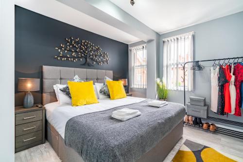 a bedroom with a large bed with yellow pillows at Elegant Flat Near Stonehenge, Amesbury Town Centre Smart TVs Netflix FREE PARKING in Amesbury