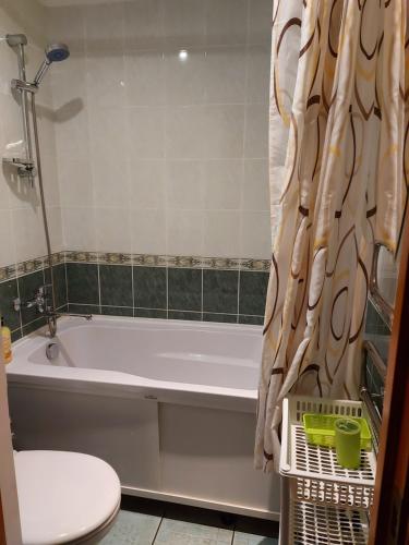 a bathroom with a tub and a toilet and a sink at Dzīvoklis in Ventspils
