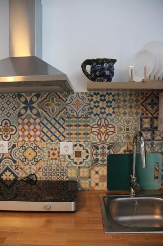 a kitchen with a sink and a tile wall at Bosque dos Amieiros in Marco de Canavezes
