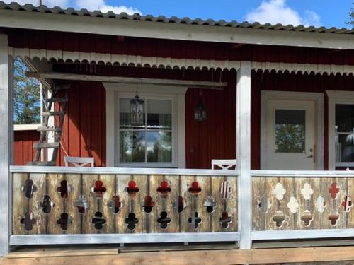 a porch of a red house with a fence at Wilderness and Calmness in Lapland in Nattavaara