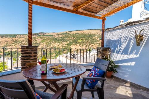 a table and chairs on a balcony with a view at Apartamentos Entre Senderos in Capileira