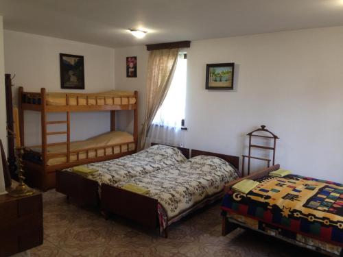 a bedroom with two bunk beds and a window at Family House Nichka in Pochayiv