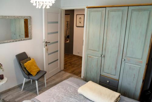 a bedroom with a bed and a chair and a closet at Apartament Sobieski in Sanok