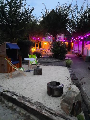 a patio with chairs and a table and purple lights at Altstadtcafé und Pension in Havelberg