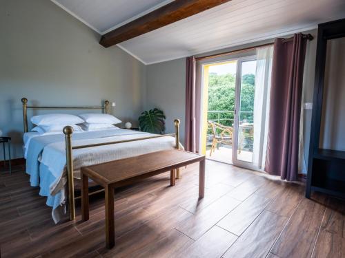 1 dormitorio con cama, mesa y puerta corredera de cristal en Villa Várzea Hiker Nest en Várzea