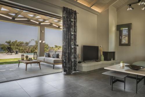 salon z kanapą i telewizorem w obiekcie Alekos Beach Houses-Elia Villas w Lixoúrion