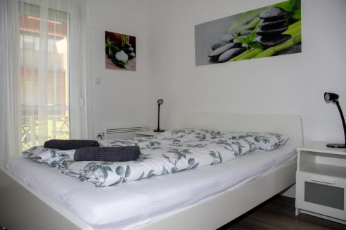 a white bed in a room with a window at Menta Lak in Balatongyörök