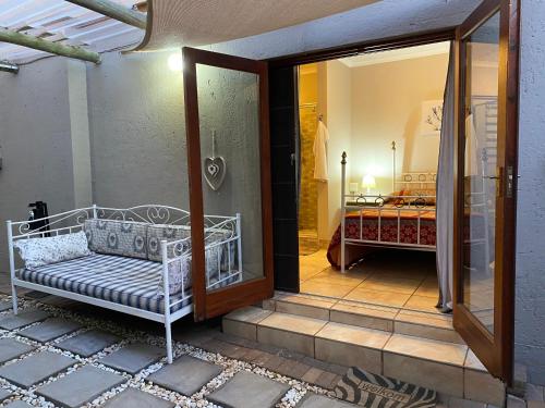 a porch with a white bench and a bedroom at Bonzila in Pretoria