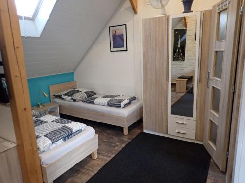 2 łóżka w niewielkim pokoju na poddaszu w obiekcie Apartmán SMRČEK w mieście Nové Město pod Smrkem