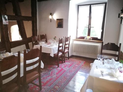 a dining room with white tables and chairs and a window at Hotel-Restaurant Bibermühle GmbH in Tengen