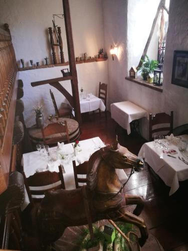 a dining room with tables and a horse on the floor at Hotel-Restaurant Bibermühle GmbH in Tengen