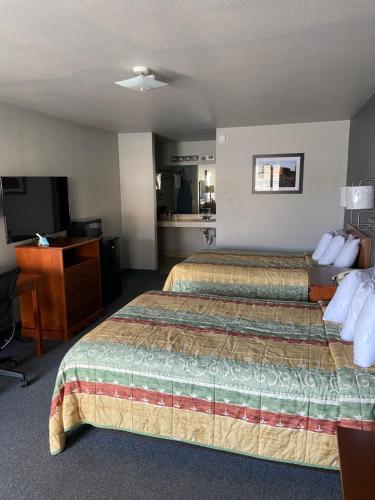 a hotel room with two beds and a television at Redbud Inn in Goldthwaite