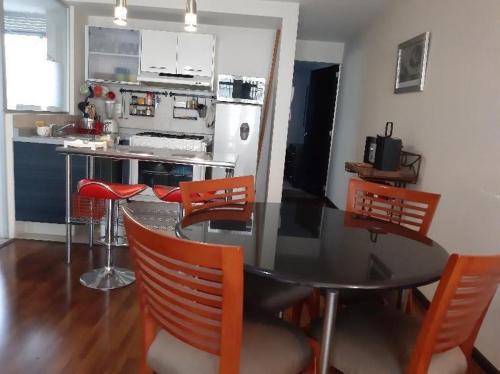 a kitchen with a dining room table and chairs at Departamento acogedor para viajeros y turistas in Mexico City