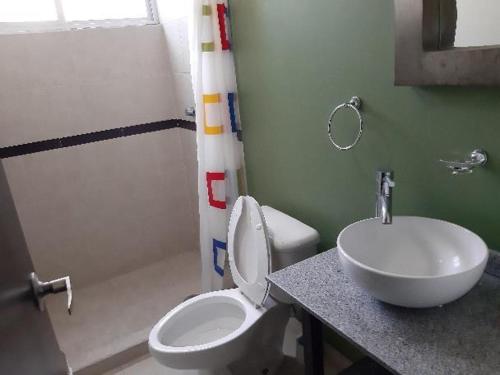 a bathroom with a white toilet and a sink at Departamento acogedor para viajeros y turistas in Mexico City