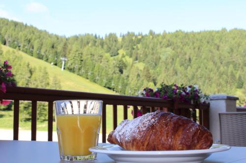 a loaf of bread and a glass of orange juice on a table at Hotel Grizzly in Folgaria