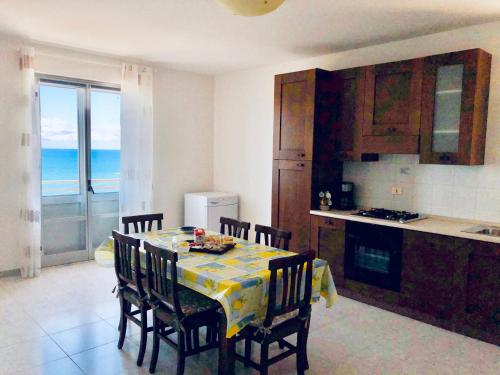 une cuisine avec une table et des chaises et l'océan dans l'établissement Attico Giusy, à Balestrate