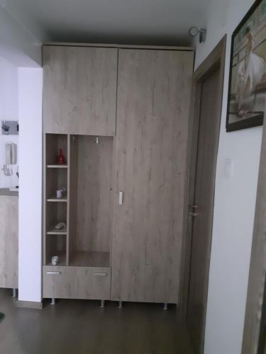 einen großen Holzschrank im Wohnzimmer in der Unterkunft Apartament particular in Râmnicu Vâlcea