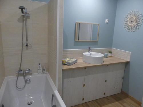 La salle de bains est pourvue d'une baignoire, d'un lavabo et d'une baignoire. dans l'établissement charmant studio 35m² au calme proche du circuit, à Saint-Gervais en-Belin