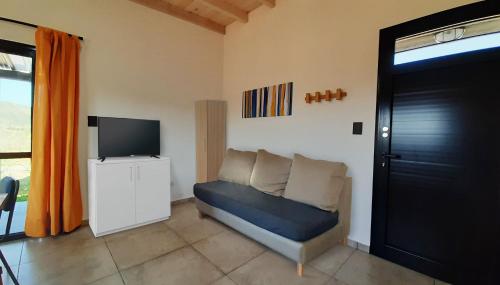 uma sala de estar com um sofá e uma televisão de ecrã plano em Cabañas Buena Vista - Santa Rosa em Santa Rosa de Calamuchita