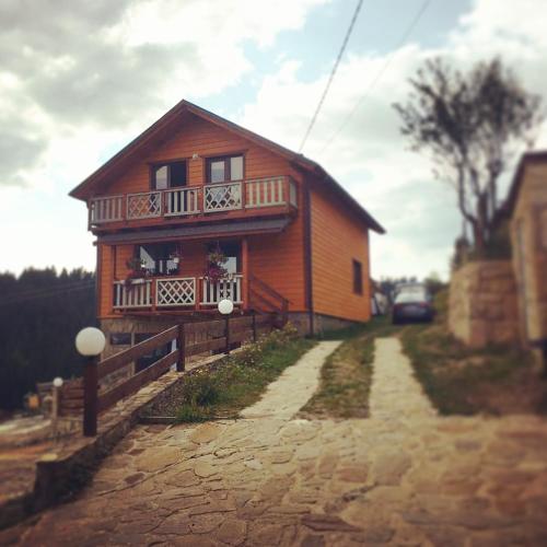 a house with a balcony on the side of a road at Вовкаль in Yablunytsya