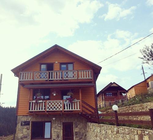 a large wooden house with a balcony on it at Вовкаль in Yablunytsya