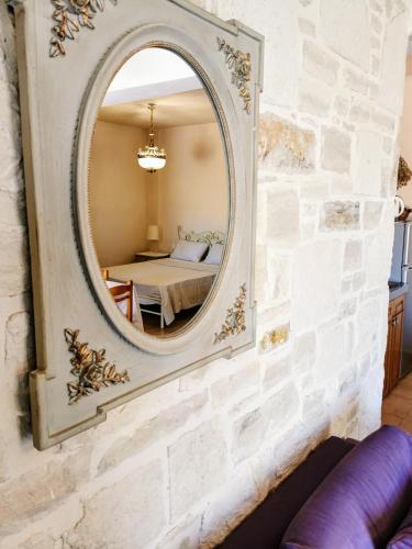 a mirror on the wall of a room with a bed at Aelia in Kamilari