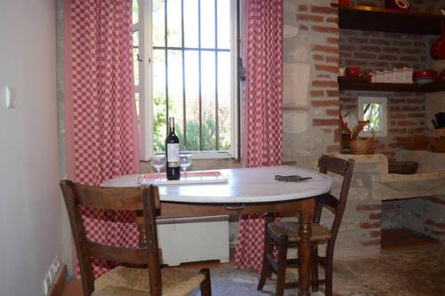 a kitchen with a table and chairs and a window at l'Empereur - La Maïsou in Sérignac
