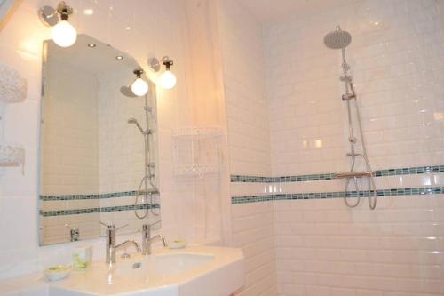 a white bathroom with a sink and a mirror at l'Empereur - La Maïsou in Sérignac