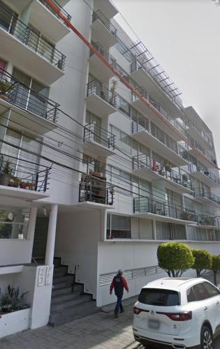 a person walking in front of a building at Departamento acogedor para viajeros y turistas in Mexico City