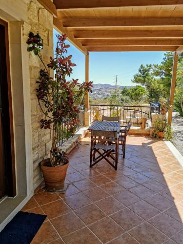 a patio with a table and a potted plant at Aelia in Kamilari