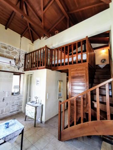 a living room with a wooden staircase and a table at Aelia in Kamilari