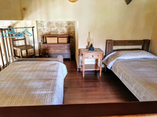 a bedroom with two beds and a table with a dresser at Aelia in Kamilari