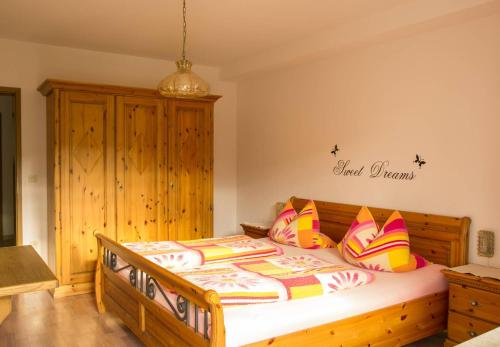 a bedroom with a wooden bed with colorful pillows at Ferienwohnung Andrea in Riedenburg