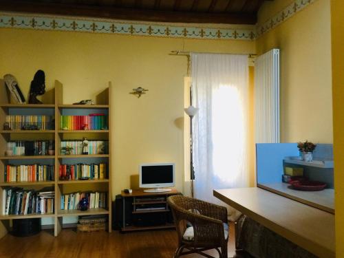 um quarto com uma secretária com um computador e prateleiras de livros em apartments in the center of Ferrara excellent for Smart work em Ferrara