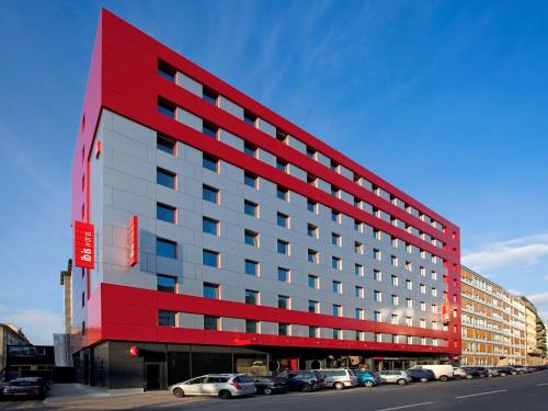 un edificio rojo con coches estacionados en un estacionamiento en ibis Genève Centre Nations en Ginebra