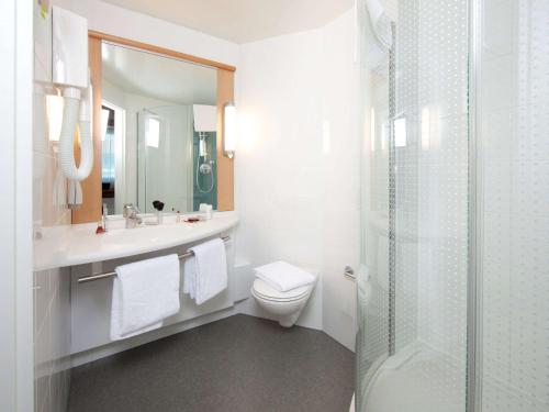 a white bathroom with a toilet and a shower at ibis Genève Centre Nations in Geneva