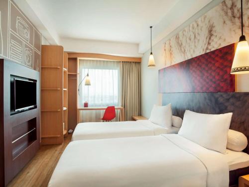 Tempat tidur dalam kamar di ibis Yogyakarta Adi Sucipto