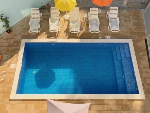 ein großer blauer Pool mit Stühlen und Sonnenschirmen in der Unterkunft Vacation Rentals Croatia in Split