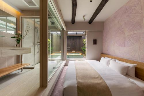 um quarto com uma cama grande e uma janela grande em Nazuna Kyoto Tsubaki St. em Quioto
