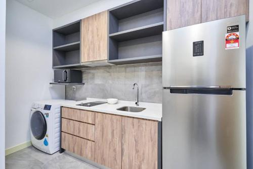a kitchen with a refrigerator and a washing machine at BotakCuteHomestay@Imperio Residence in Melaka