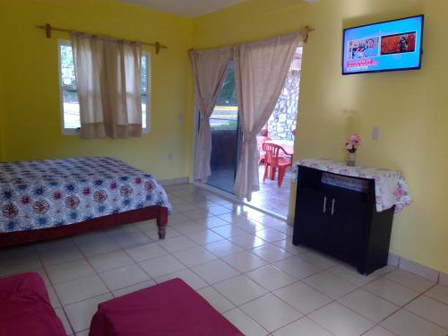a bedroom with a bed and a table and a window at Departamento full equipped in Puerto Escondido