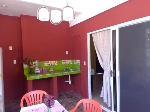 a dining room with red walls and a green shelf at Departamento full equipped in Puerto Escondido