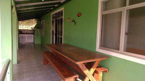 un banco de madera en una habitación con una pared verde en Residencial Caminho das Praias en Bombinhas