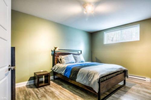 1 dormitorio con 1 cama en una habitación con paredes verdes en 3BDRM Zen Tremblant Chalet - Ski/Hike/Swim en Lac-Superieur