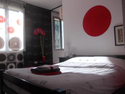 a bedroom with a bed and a red circle on the wall at L'Xpérience in Valgorge