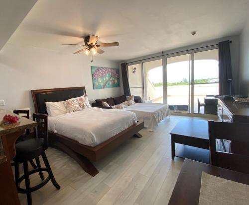 a bedroom with two beds and a ceiling fan at La Vista Azul Resort - Studio in Turtle Cove