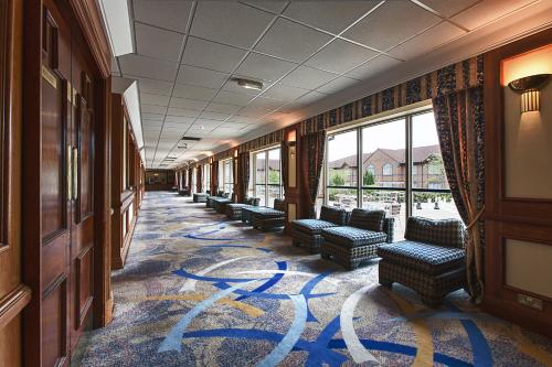 a hallway with chairs and windows in a building at Mercure Daventry Court Hotel in Daventry