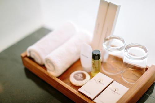 a wooden tray with towels and cosmetics on a table at Mahogany Hotel in Nusa Dua