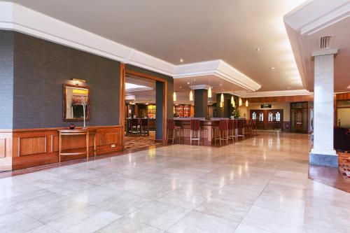 a large lobby with a bar in a building at Mercure Daventry Court Hotel in Daventry